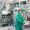 RNA-Produktion bei Novartis, Mann in Schutzkleidung an Bedienterminal, Biopharmazie, Biotechnologie, Fermenter, Messtechnik,
