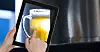 Hand taking picture of beer glass through digital tablet