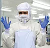 Lab worker in Protective Clothes and mask with gloves for doing