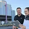 Data-Science-Experte Frank Mollard und Betriebsassistentin Jasmin Krimm von Infraserv Höchst vor einem Rückkühlwerk im Industriepark Höchst