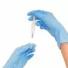 Hände in blauen Latex-Handschuhen ziehen Spritze auf