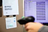 verschwommenes Scanner Handgerät mit Monitorbild im Hintergrund