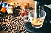 Kaffeemaschine mit Espresso, im Hintergrund Kapseln