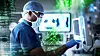 Chirurg im Operationssaal arbeitet an einem Monitor mit digitalen Datenanzeigen