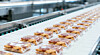 Verpackte Lebensmittel auf einem Förderband in einer Produktionsanlage.