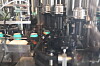 Industrieanlage mit Metallrohren, Maschinenteilen und Fördertechnik in einer Produktionshalle.