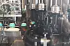 Industrieanlage mit Metallrohren, Maschinenteilen und Fördertechnik in einer Produktionshalle.