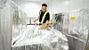 Mitarbeiter untersucht eine silbern verpackte Fracht in einer Lagerhalle.