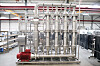 Rohrleitungen und Ventile in einer Industriehalle mit Metallkonstruktion und technischen Anlagen.