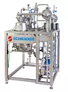 Edelstahl-Produktionsanlage von Schrader mit Rohren, Ventilen und Behältern auf weißem Hintergrund.