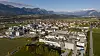 Standort Kundl, Österreich: Panoramablick auf eine Stadt mit Gebäuden, Feldern und Bergen im Hintergrund.