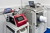 Laboraufbau mit rotem Bediengerät, Laptop und großem optischen Messsystem auf einem Tisch.