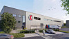 Fiege-Logistikhalle mit Logo, Lieferwagen und Straße vor dem Gebäude.