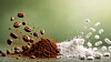 Weiße Tabletten und Kapseln neben braunem Pulver und Staubwolke auf einer Oberfläche.