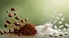 Weiße Tabletten und Kapseln neben braunem Pulver und Staubwolke auf einer Oberfläche.